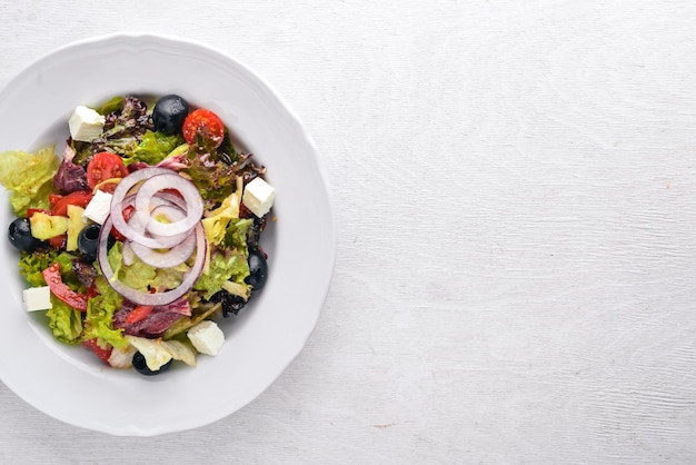 Griechischer Salat Frisches Gemüse auf einem hölzernen Hintergrund Ansicht von oben Freier Platz für Text