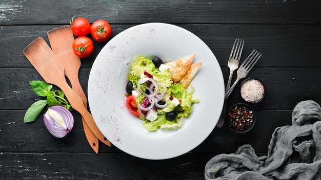 Griechischer Salat. Gemüsesalat mit Schafskäse, Oliven und Kirschtomaten. Im Teller. Ansicht von oben. Freiraum für Ihren Text. Rustikaler Stil.