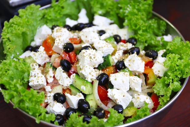 Foto griechischer salat in schüssel auf einem tisch