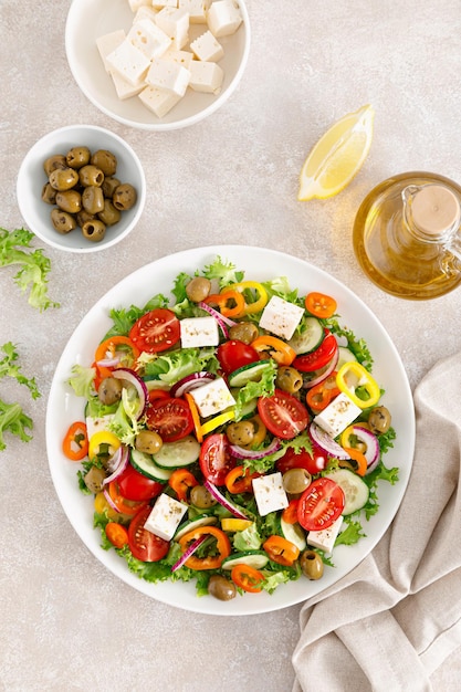 Griechischer Salat mit Feta-Käse, Tomaten, Gurken, Paprika, roten Zwiebeln und grünen Oliven Draufsicht