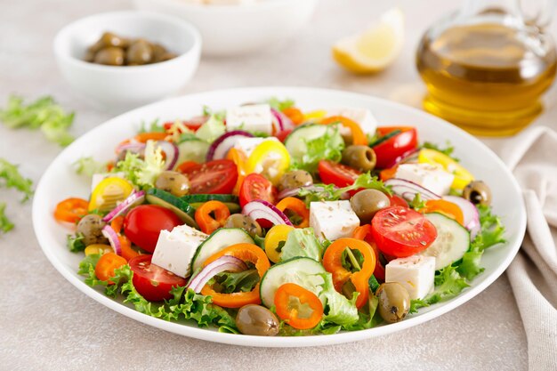 Griechischer Salat mit Feta-Käse, Tomaten, Gurken, Paprika, roten Zwiebeln und grünen Oliven Draufsicht