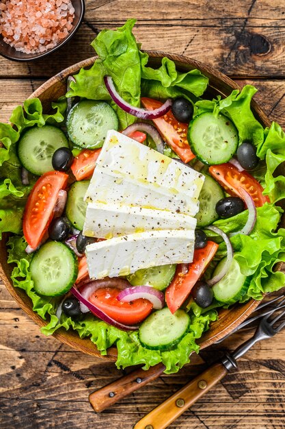 Griechischer Salat mit frischem Gemüse und Feta-Käse. Holztisch. Draufsicht.