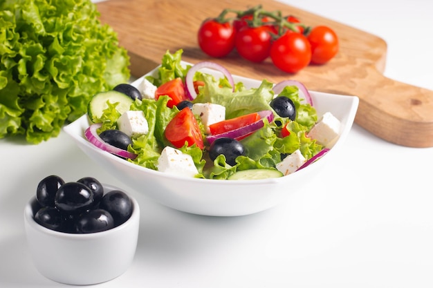 Griechischer Salat mit frischen Tomaten, Gurken, Oliven, Feta-Käse und roten Zwiebeln