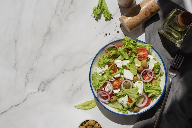 Griechischer Salat mit Gemüse und Käse auf einem grauen Tisch