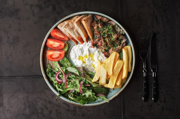 Griechisches Gyros mit Huhn oder Kalb mit Tzatziki auf dunklem Hintergrund