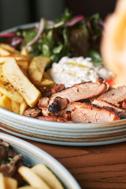 Foto griechisches gyros mit huhn oder kalb mit tzatziki auf dunklem hintergrund