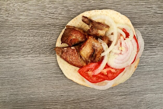 Griechisches Souvlaki mit Fladenbrot und Gemüse Nahaufnahme auf dem Tisch Pita-Tisch aus Schweinefleisch