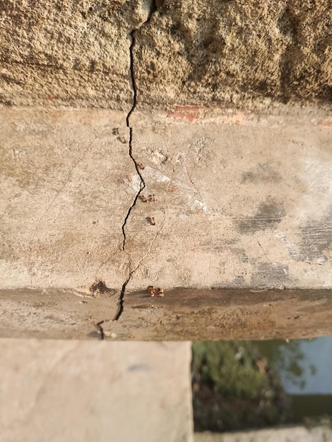 Una grieta en un muro de hormigón con agua azul en el fondo.