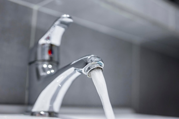 Grifo de agua Flujo de agua en el baño con lavabo Concepto de higiene moderno y limpio