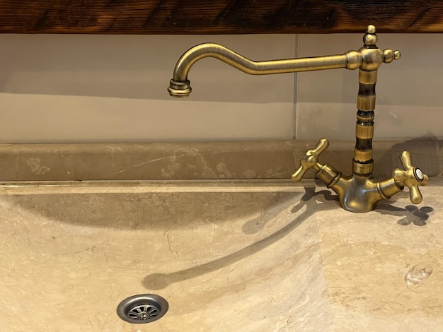 Grifo de bronce en un lavabo de granito en el baño.