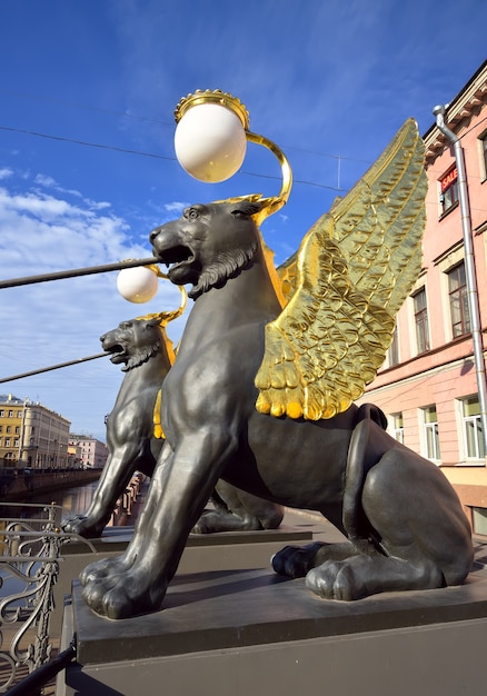 Grifos del puente del Banco en el canal Griboyedov Dos esculturas de criaturas míticas con alas doradas sostienen un puente peatonal Arte del siglo XIX