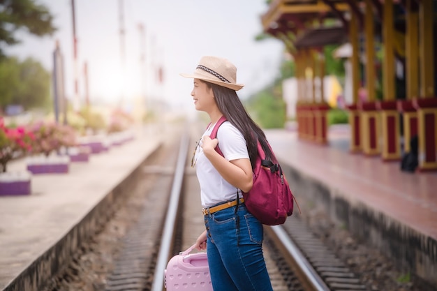 Gril asiático joven caminando en la estación de tren antes de viajar. concepto de trabajo y viajes.