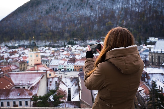 Gril tomando una foto de una ciudad vieja