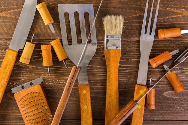 Grill-Kochset aus Edelstahl mit Holzgriffen.