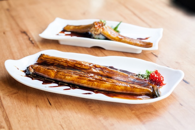 grill unagi pescado con salsa con plato blanco en restaurante japonés