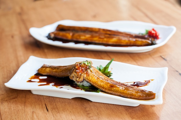 grill unagi pescado con salsa con plato blanco en restaurante japonés