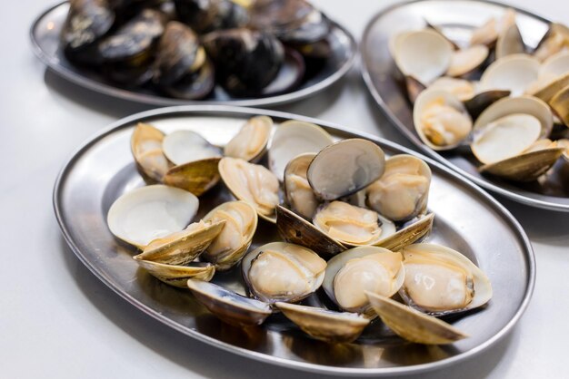 Grillar almejas de mariscos en el mercado callejero