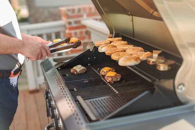 Grillen klassischer Burger auf dem Gasgrill im Freien im Sommer.