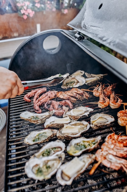 Grillen mit Meeresfrüchten. Sammlung von Tintenfischen, Austern, Muscheln, Tigergarnelen auf dem Grill gegrillt