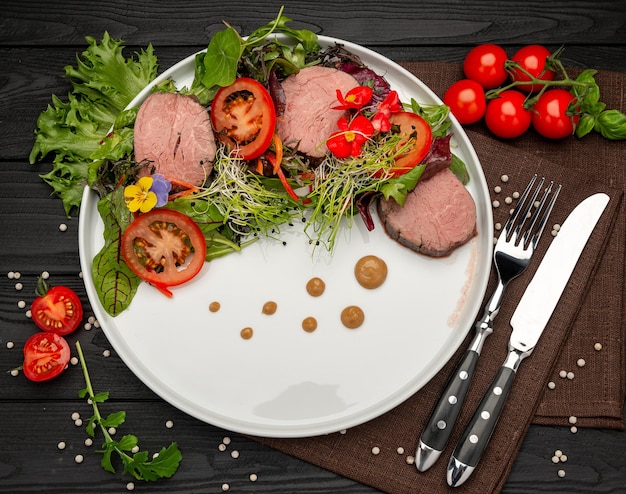 Grillen Sie trocken gereiftes Wagyu-Entrecote-Rindsteak mit Salat und Tomaten