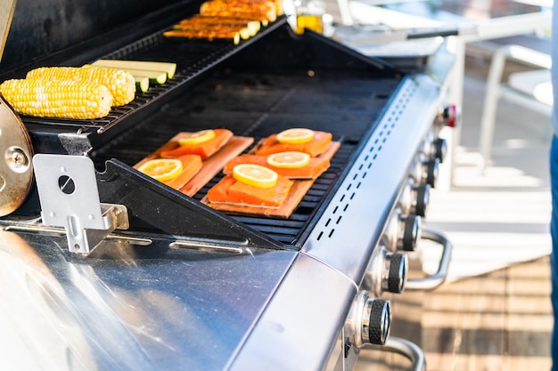 Grillen von Lachs auf einem Gasgrill auf der Terrasse im Hinterhof.