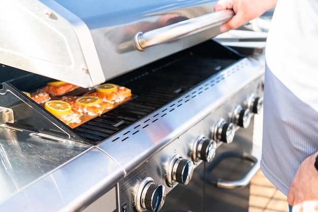 Grillen von Lachs auf einem Gasgrill auf der Terrasse im Hinterhof.