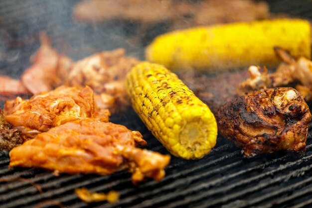 Grillen von Maiskolben, Hähnchenkeulen und Garnelen