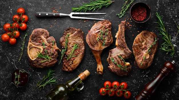 Grillmenü Grillsteaks Draufsicht Flache Draufsicht auf Schneidetisch aus schwarzem Stein