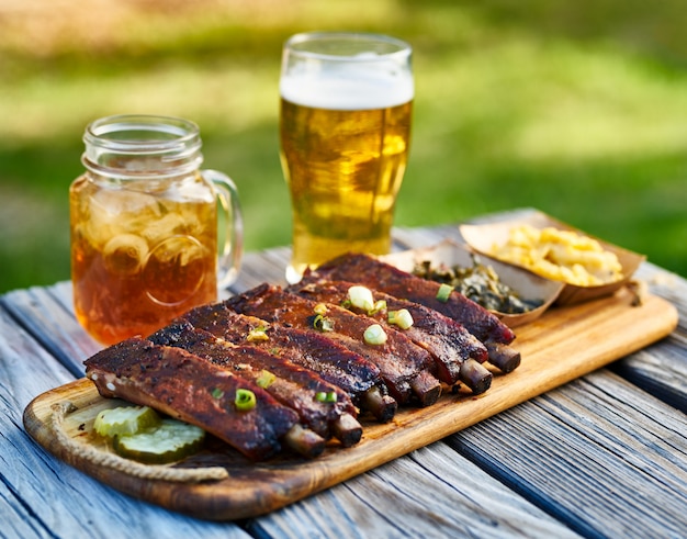 Grillrippen im St. Louis-Stil mit Kohlgrün und Mac & Cheese im Freien