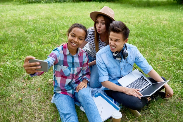 Grimassierende Teenager, die Selfie im Park nehmen