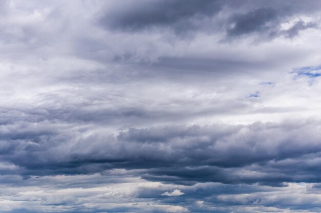 Gris entrante cerca de nubes de tormenta en el telón de fondo de la luz del día