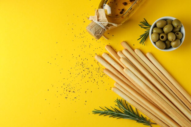 Grissini, azeitonas, azeite e especiarias em amarelo