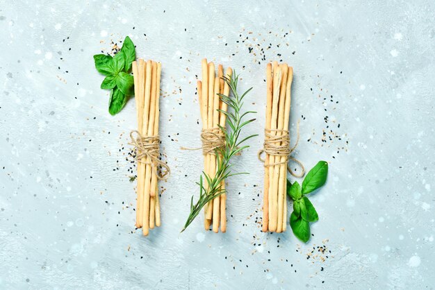 Grissini Palitos de pan con romero y albahaca sobre un fondo de piedra gris Comida Vista superior Espacio libre para texto