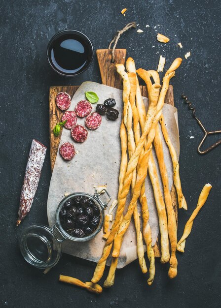 Grissini-Stäbchen Speckwurst Oliven und Rotwein