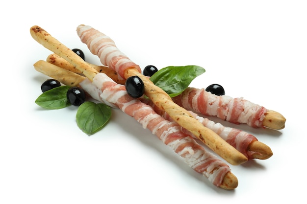 Grissini varas com bacon, azeitonas e manjericão isolado na superfície branca