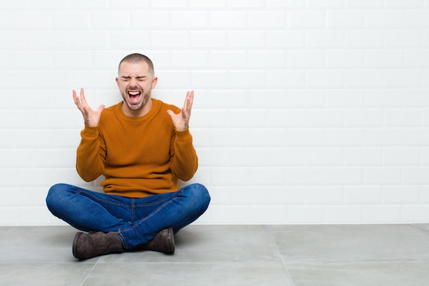 gritando furiosamente, sentindo-se estressado e irritado com as mãos no ar dizendo por que eu