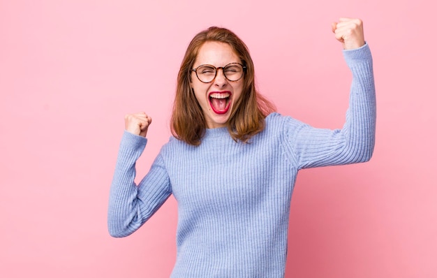 Gritando triunfalmente luciendo como un ganador feliz y sorprendido emocionado celebrando