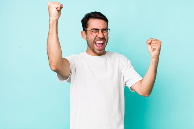 Gritando triunfalmente luciendo como un ganador feliz y sorprendido emocionado celebrando