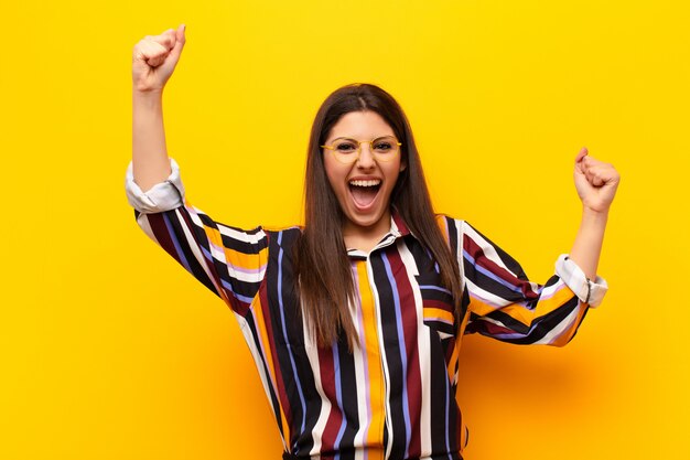 gritando triunfante, luciendo emocionado, feliz y sorprendido ganador, celebrando