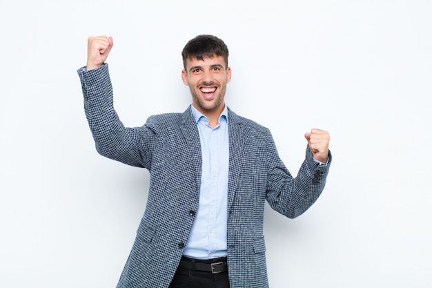 gritando triunfante, luciendo emocionado, feliz y sorprendido ganador