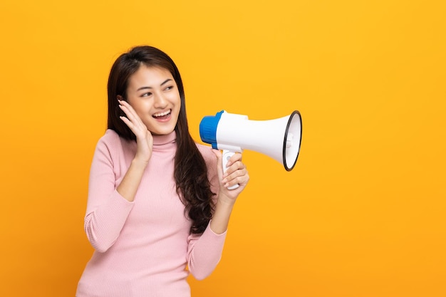 Grite em voz alta com megafone Jovem mulher asiática bonita anuncia com voz sobre promoções e anúncios de produtos a um preço com desconto Conceito de compras e moda