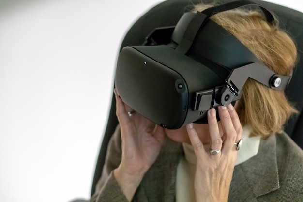 Grodno Belarus junho 012020 Uma mulher adulta usando óculos de realidade virtual Usando tecnologias VR na vida cotidiana Introdução da ciência da realidade aumentada e tecnologia do futuro na vida