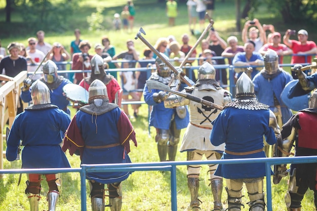 GRODNO BIELORRÚSSIA JUNHO 2019 grupo de cavaleiros de justa medieval luta em capacetes de armadura cota de malha com machados e espadas em listas reconstrução histórica da luta antiga