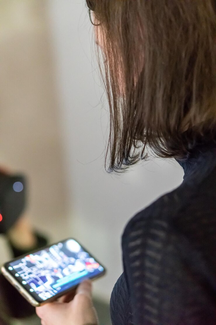 Foto grodno bielorrusia 01 de junio de 2020 una chica joven y bonita con una chaqueta negra con un teléfono en las manos mira el teléfono