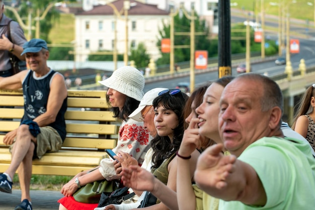 Grodno Bielorrusia 10 de julio de 2022 Un anciano con su familia descansa en el parque sentado en un banco Un jubilado con su nieta en un concierto al aire libre El hombre sonríe alegremente