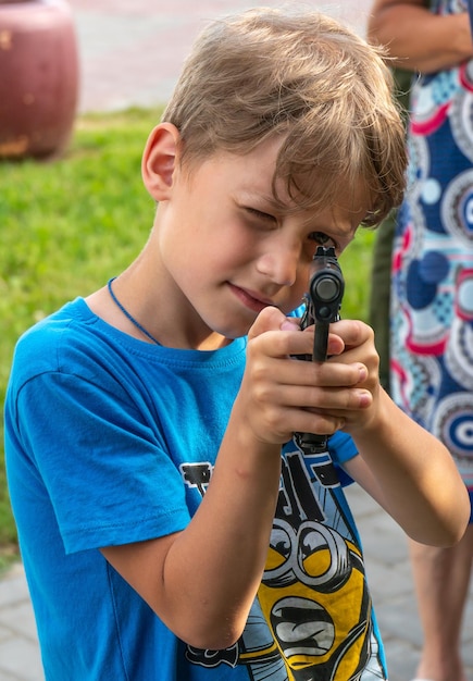 Grodno Bielorrusia 10 de julio de 2022 Un niño sostiene un arma y apunta a un fotógrafo en una exposición de armas de fuego Problemas con la proliferación de armas en Estados Unidos