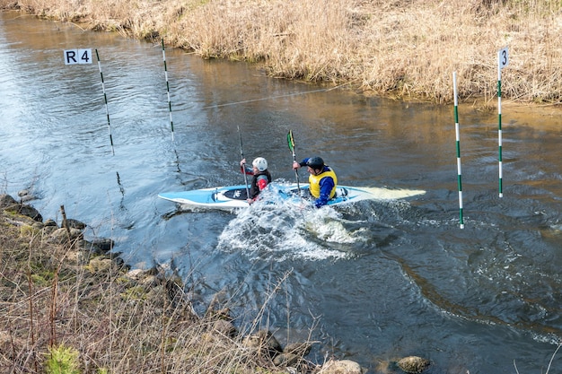 GRODNO BIELORRUSIA ABRIL 2019 competencia de estilo libre de kayak en un río rápido de agua fría remando enérgicamente espíritu de victoria