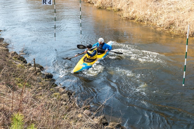 GRODNO BIELORRUSIA ABRIL 2019 competencia de estilo libre de kayak en un río rápido de agua fría remando enérgicamente espíritu de victoria