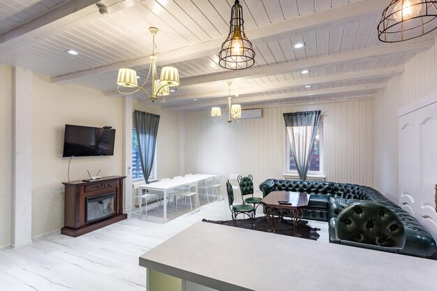 GRODNO BIELORRUSIA AGOSTO 2019 Loft interior de salón de lujo con diseño de estilo gris con chimenea de cocina verde y sofá Chester