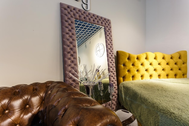 GRODNO BIELORRUSIA DICIEMBRE 2018 espejo sofá y cama en estilo chester para interior de loft de élite en tienda cara sala de exposición de muebles